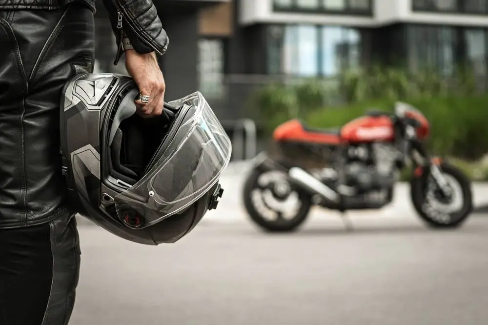 Photo of a Biker next to his motorcycle
